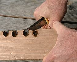 Shaping the wooden board with knife.