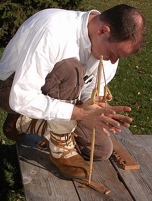 Man drilling the spindle with hands for fire.