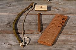 Bow, stick, and two wooden boards are being displayed.