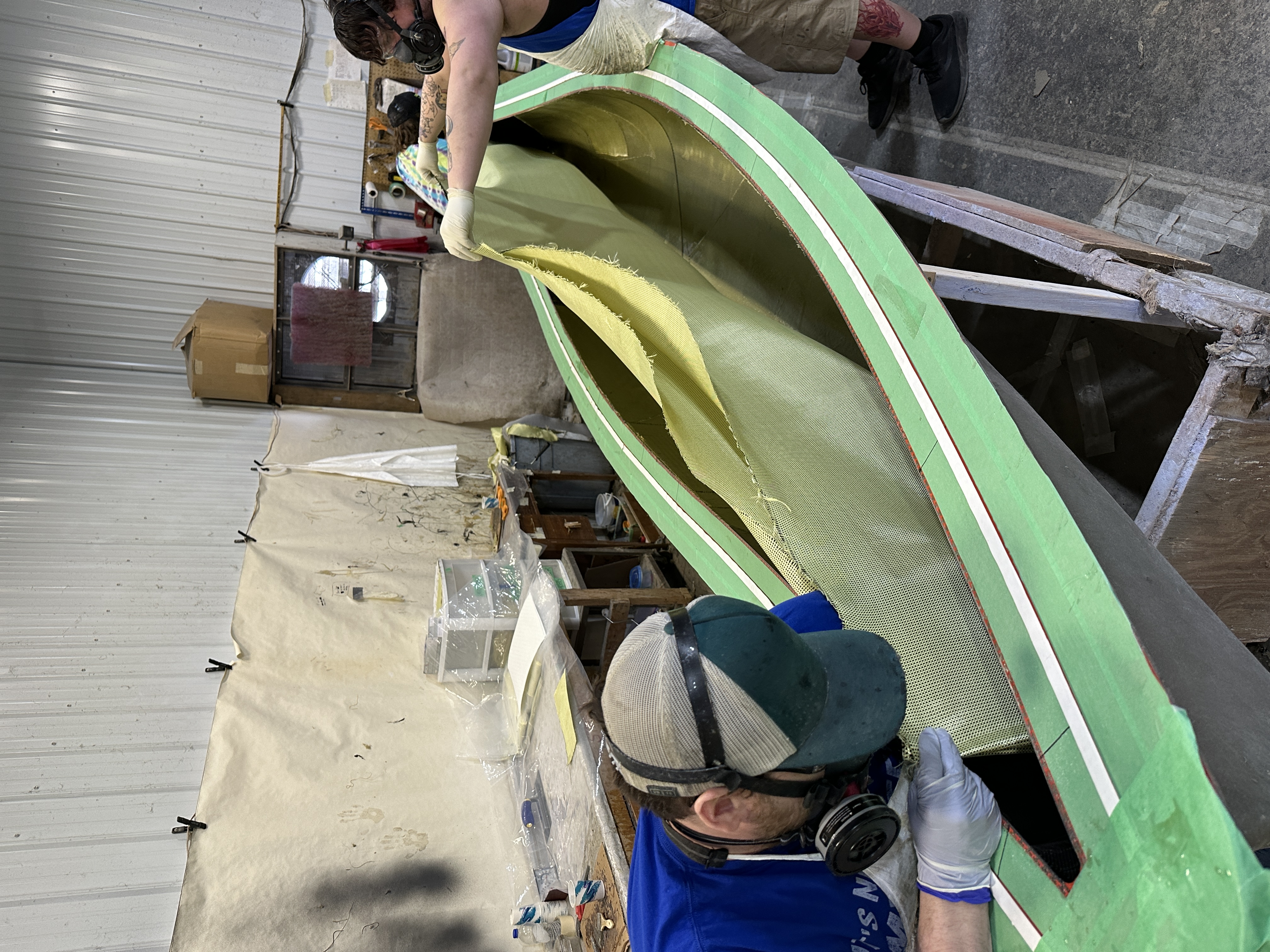 Putting Kevlar fabric into a canoe mold.